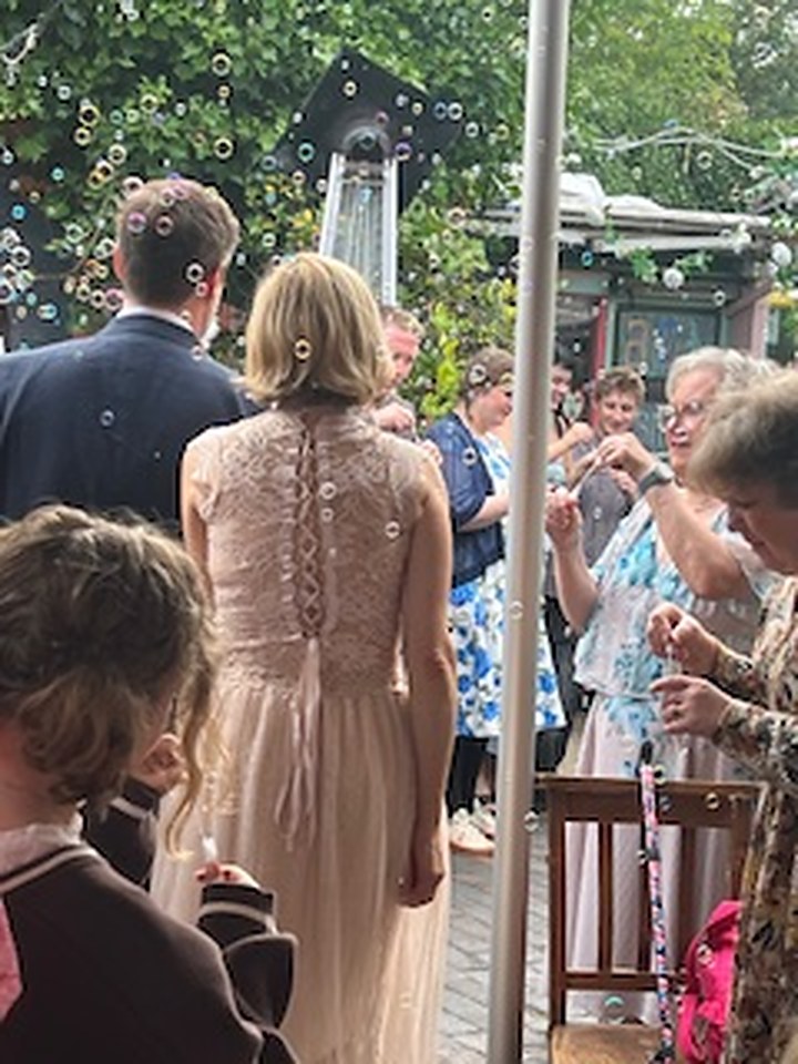 Carolin and George walking through a bubble send-off at Kitchen Garden Cafe
