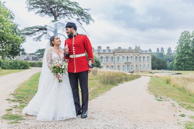 Tia and Sunny walking together under an umbrella at Compton Verney